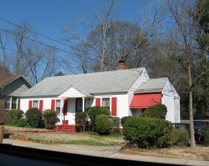 How cute is this house?!  I love the red awning and shutters.